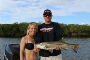 Captain Jason with fishing charter customer holding a Snook